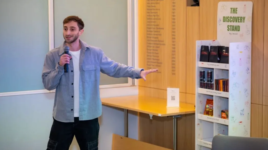 Joe Woolf presenting beside a Discovery Stand retail display unit